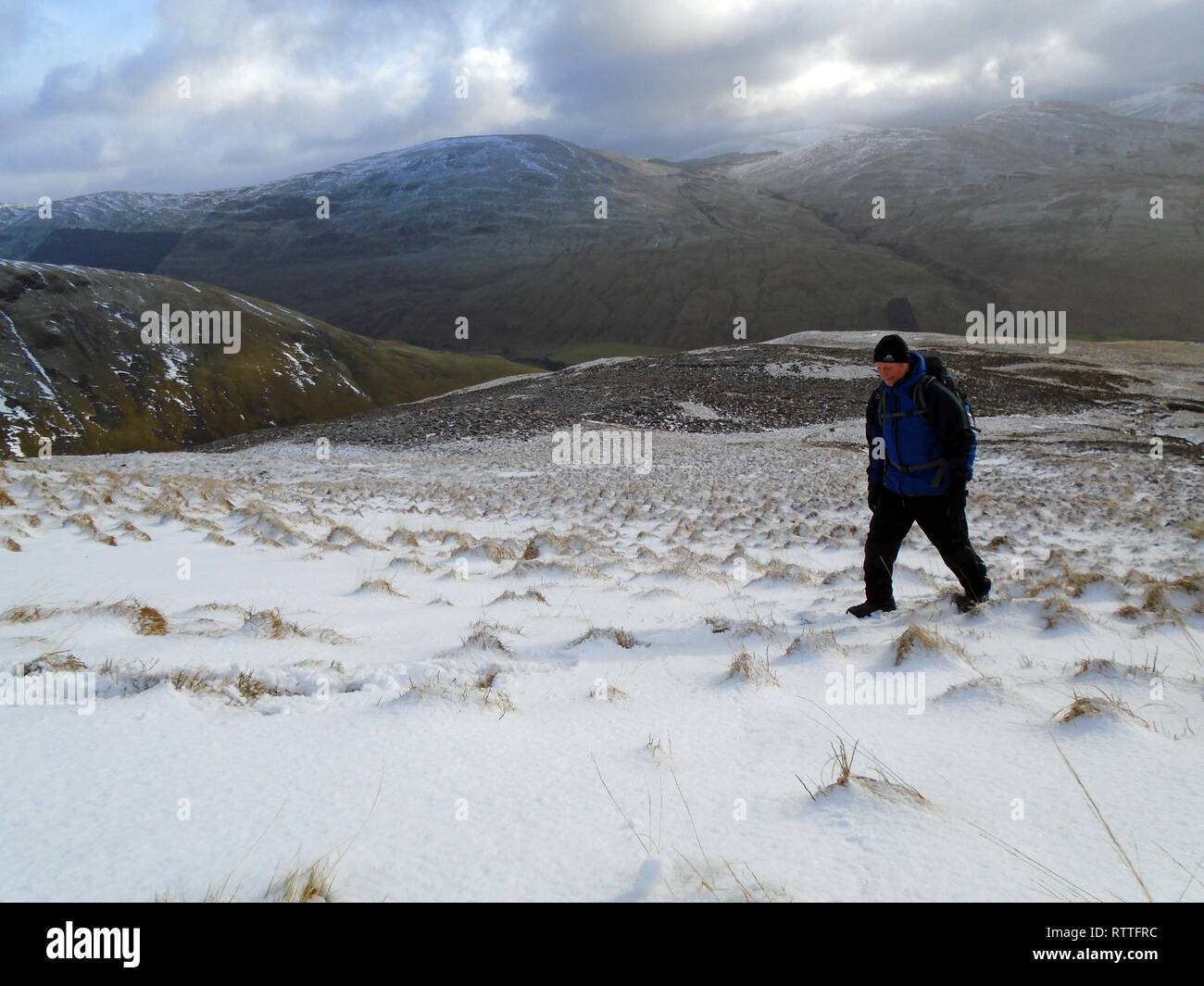 Einsame männliche Wanderer Wandern im Schnee auf dem Weg zur schottischen Berge Corbett Hart fiel, Moffat Dale, Scottish Borders, Schottland, Großbritannien Stockfoto