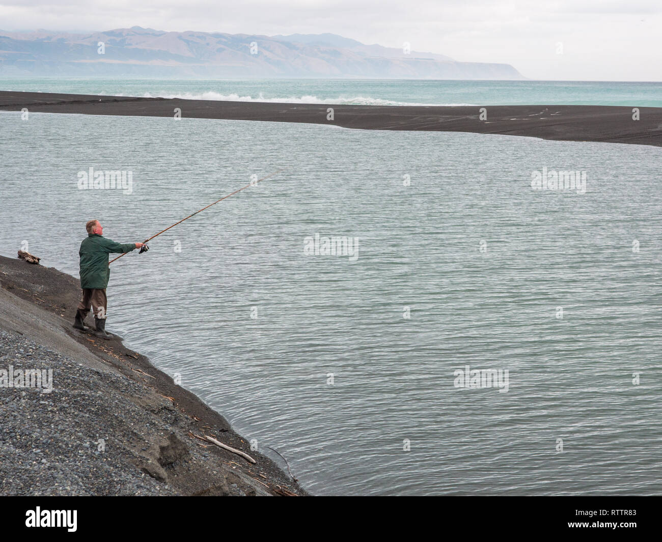Fischer mit Angelrute, Casting, See Fähre, Palliser Bay, Wairarapa, Neuseeland Stockfoto