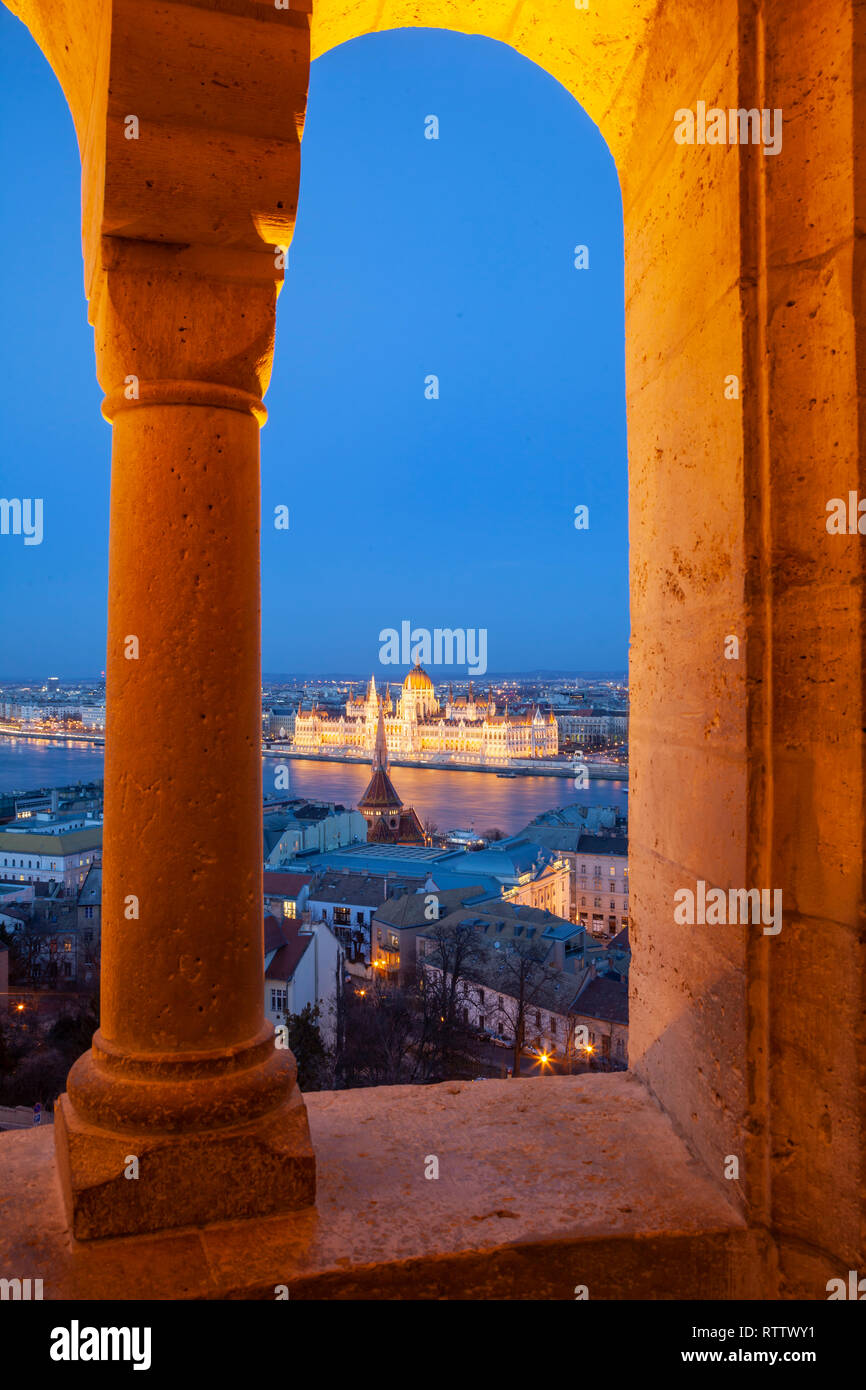 Ungarisches Parlament durch die Bögen von Fisherman's Bastion in der Dämmerung, Budapest, Ungarn gesehen. Stockfoto