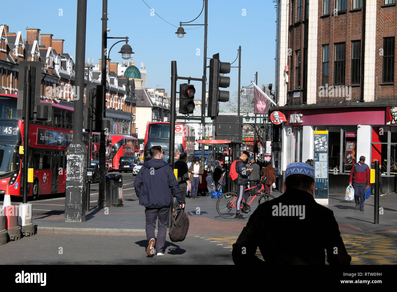 Menschen zu Fuß entlang beschäftigte Brixton Road überqueren der Straße an der Ampel und Busse in Brixton, Stadtteil Lambeth, South London UK KATHY DEWITT Stockfoto
