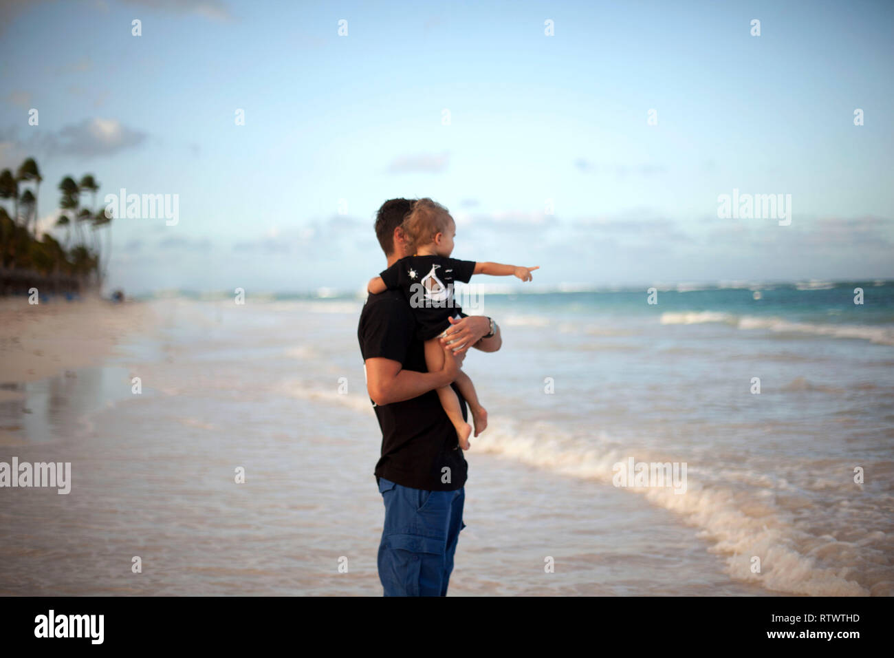 Vater und Tochter zusammen spielen am Strand bei Sonnenuntergang Stockfoto