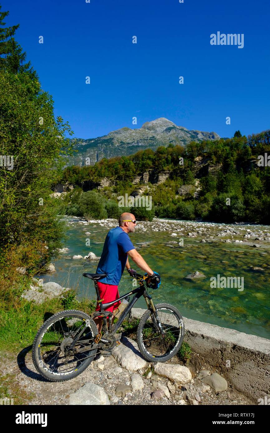 Radfahrer, Mountainbiker am Fluss Soca oder Isonzo, Berg Rombon auf der Rückseite, in der Nähe von Bovec, Soca Tal, Slowenien Stockfoto