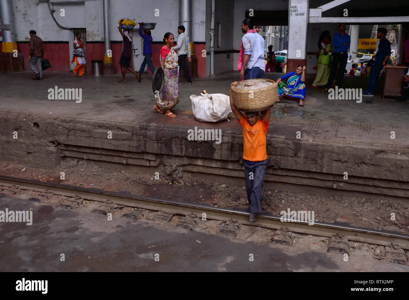 Ein Portier an Chhatrapati Shivaji Maharaj Terminus, der verkehrsreichste Bahnhof in Mumbai, Indien, gefährliche Kreuzung einer Bahnstrecke für eine Verknüpfung Stockfoto