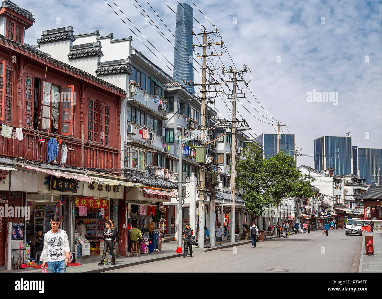 Ein Blick auf die Straße in der Altstadt von Shanghai. Wäsche hängt heraus auf das Fenster schienen der alten Häuser, hinter denen die Shanghai Turm erhebt sich zu trocknen. China. Stockfoto