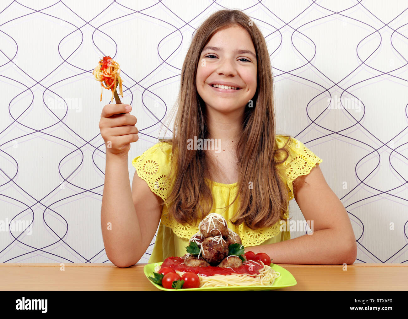Happy Teenager mit Fleischbällchen und Spaghetti zum Mittagessen Stockfoto
