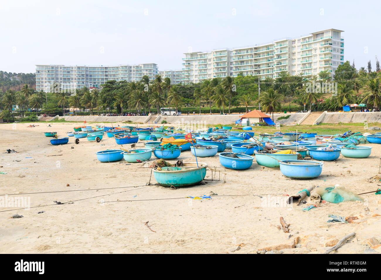 NAM TIEN, VIETNAM - 16. FEBRUAR 2018: Viele runde blaue und grüne Fischerboote auf sandigen Boden in Nam Tien, Vietnam Stockfoto