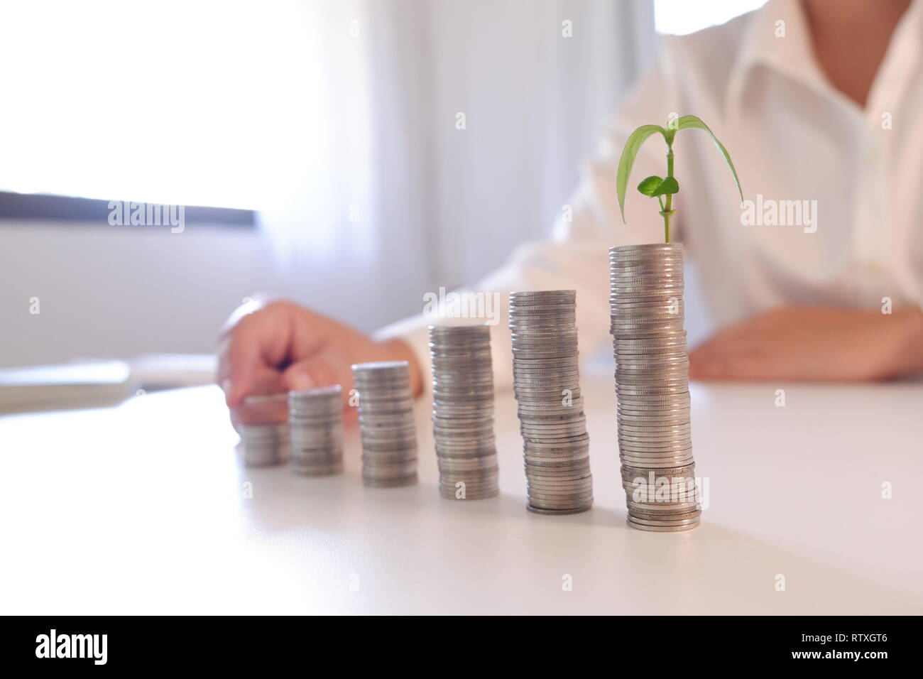 Wachsende Pflanze auf coin stack Zeile von Münzen, die für den Finanz- und Banksektor Konzept Stockfoto