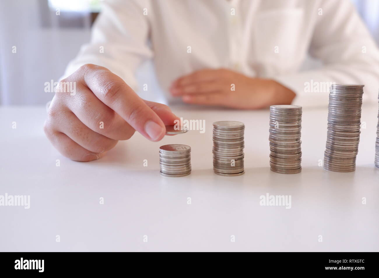 Business Person, Münze über die Münzen, die Stapel auf dem Schreibtisch. Stockfoto