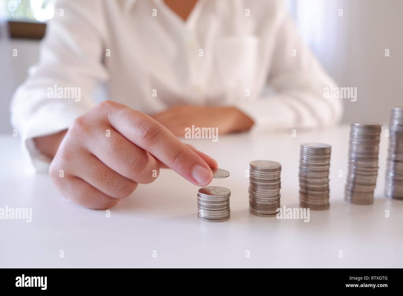 Business Person, Münze über die Münzen, die Stapel auf dem Schreibtisch Stockfoto