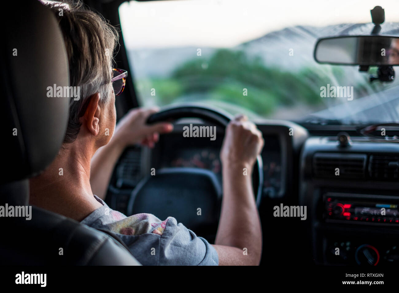 Adulta kaukasischen Lady fahren und der Weg in die Zukunft - Konzept von Reisen mit dem Auto und haben care-Versicherung für Frauen - Stockfoto