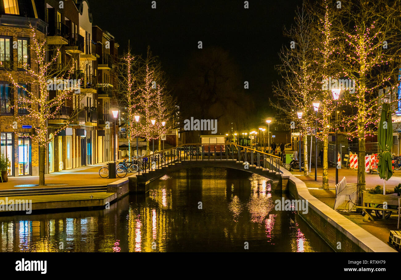 Kanalbrücke im Zentrum von Alphen aan den Rijn, Niederlande, geschmückte Bäume mit Licht, Niederländische Stadt Architektur Stockfoto