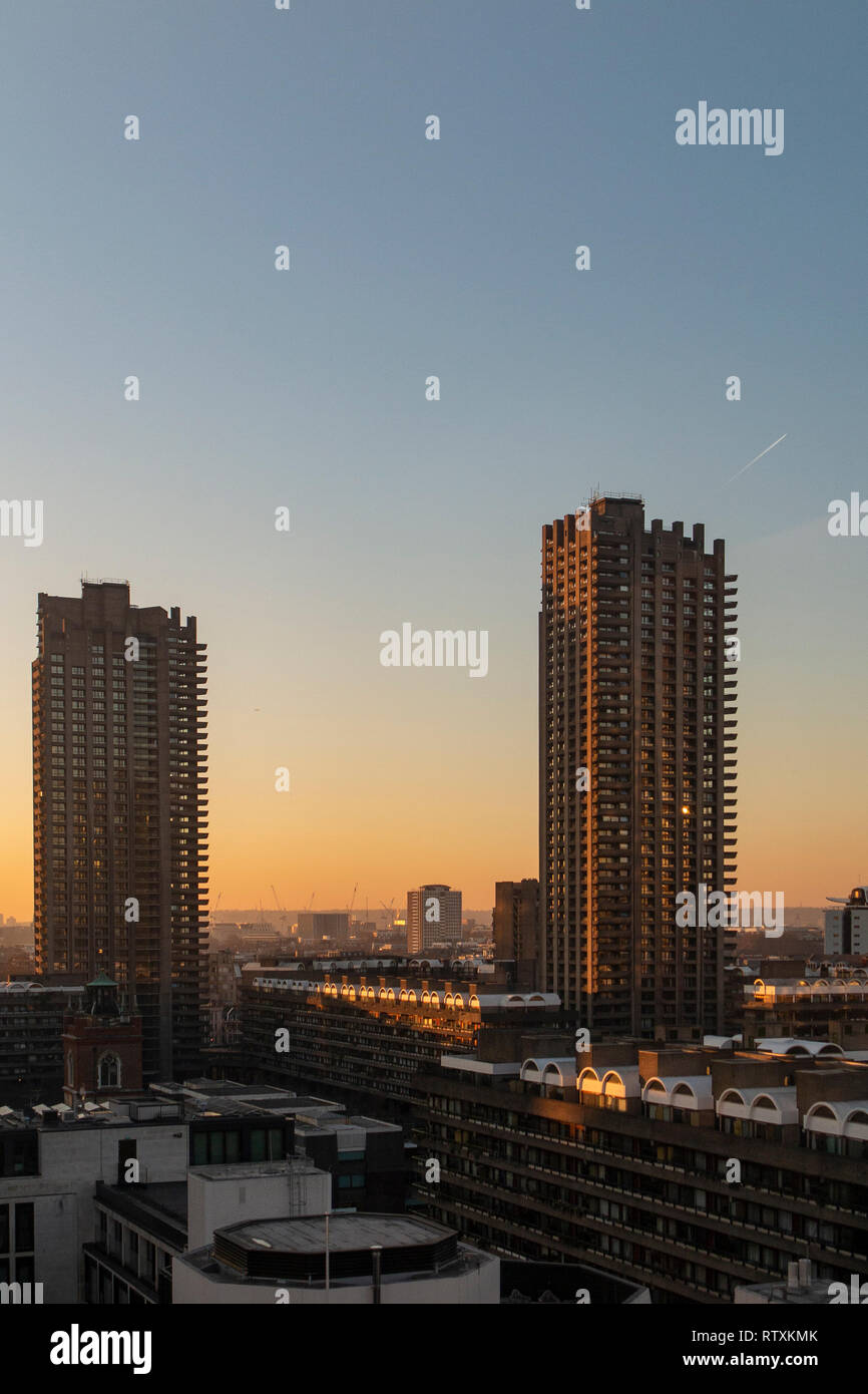 Die großen brutalist tower Blocks des Barbican Centre in London, da die Sonne untergeht Stockfoto