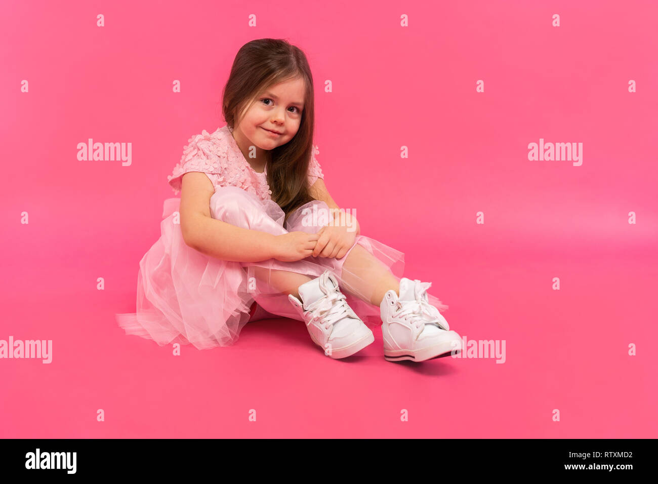 Kleines Mädchen, Studio Portrait von schönes Kind in rosa Kleid über rosa Hintergrund. Stockfoto