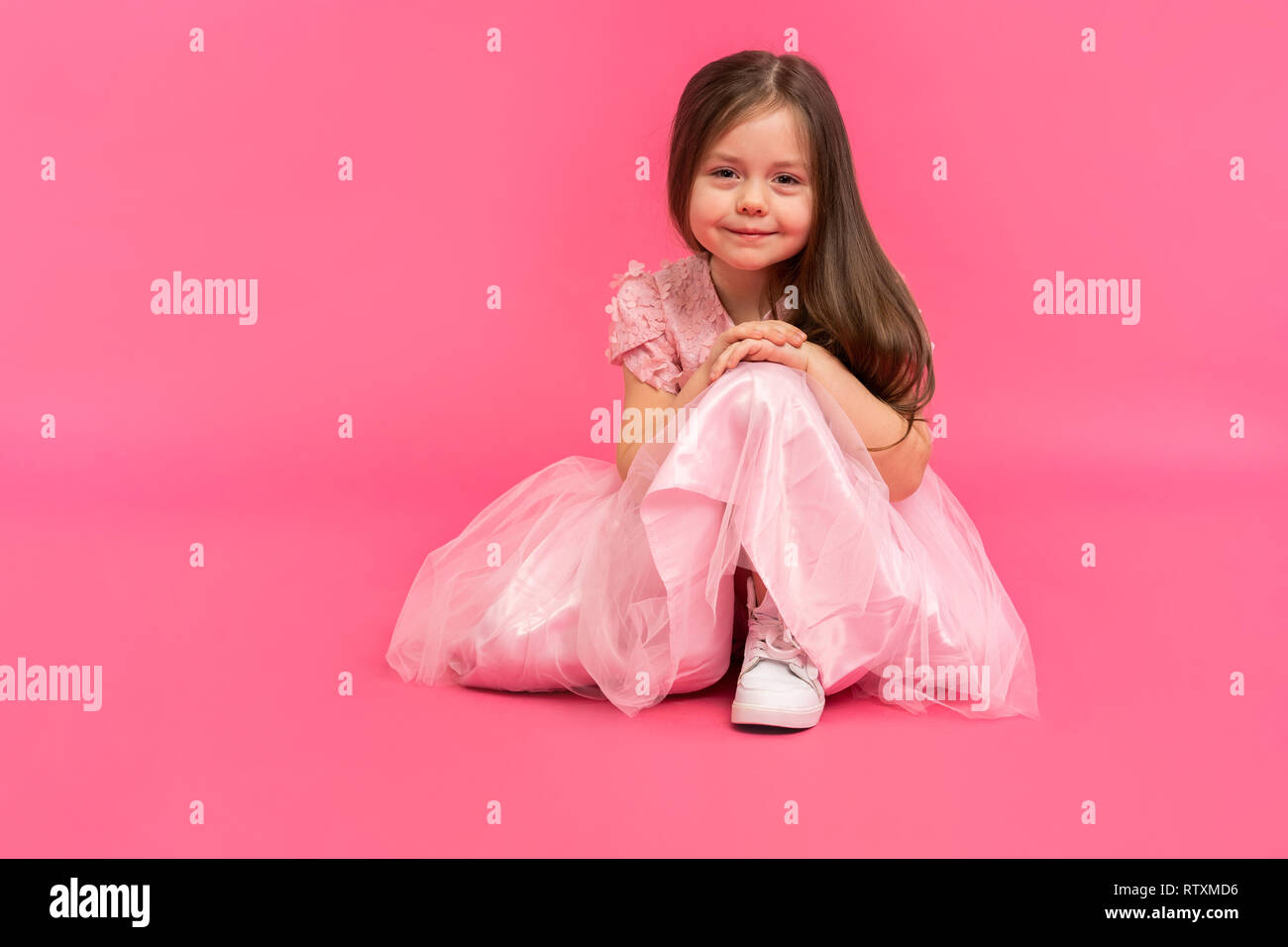 Kleines Mädchen, Studio Portrait von schönes Kind in rosa Kleid über rosa Hintergrund. Stockfoto