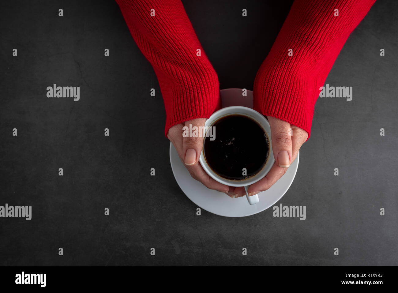 Frauen das Tragen der Roten Brücke, ihre Hände halten Tasse heißen Kaffee auf Stein Hintergrund Stockfoto