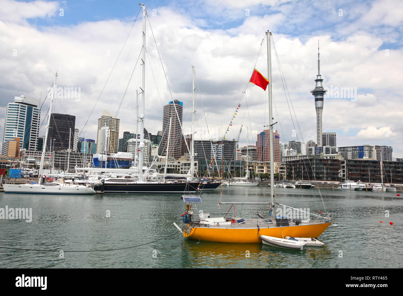 Blick auf die Stadt von Auckland, mit hohen Anstieg skyscrappers im Hintergrund und einem gelben Segelboot in den Vordergrund, North Island, Neuseeland. Stockfoto