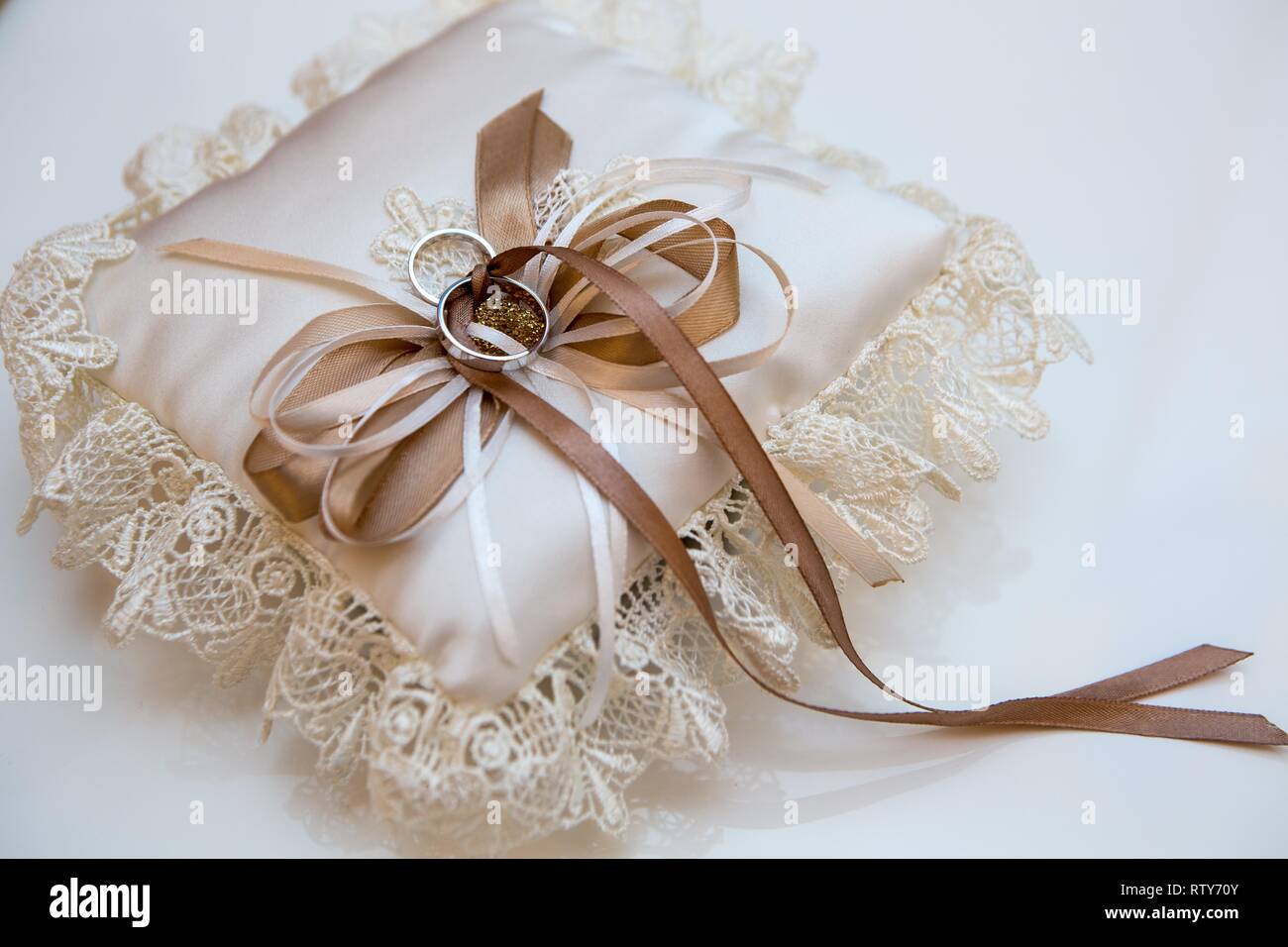 Hochzeit Zubehör, bestickter spitze Kissen mit Ringen der Braut und des Bräutigams, noch Leben in Creme beige Farben Stockfoto