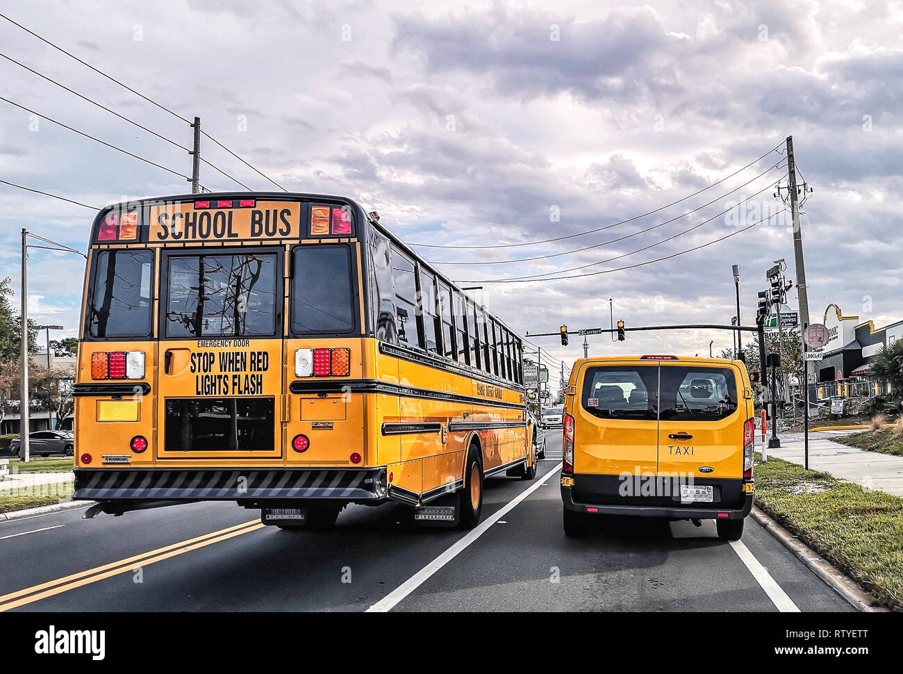 Schöne Aussicht von Yellow School Bus und Taxi auf den Straßen von Orlando, Florida, USA. Stockfoto