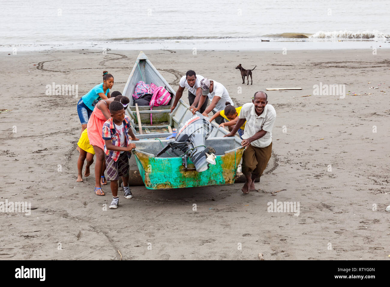 San Pedro, Esmeraldas, Ecuador, 1. Oktober 2018: eine Familie von Fischer kehrt nach einer Reise mit der Familie und sie ziehen ihr Boot aus dem Wasser zu Protec Stockfoto