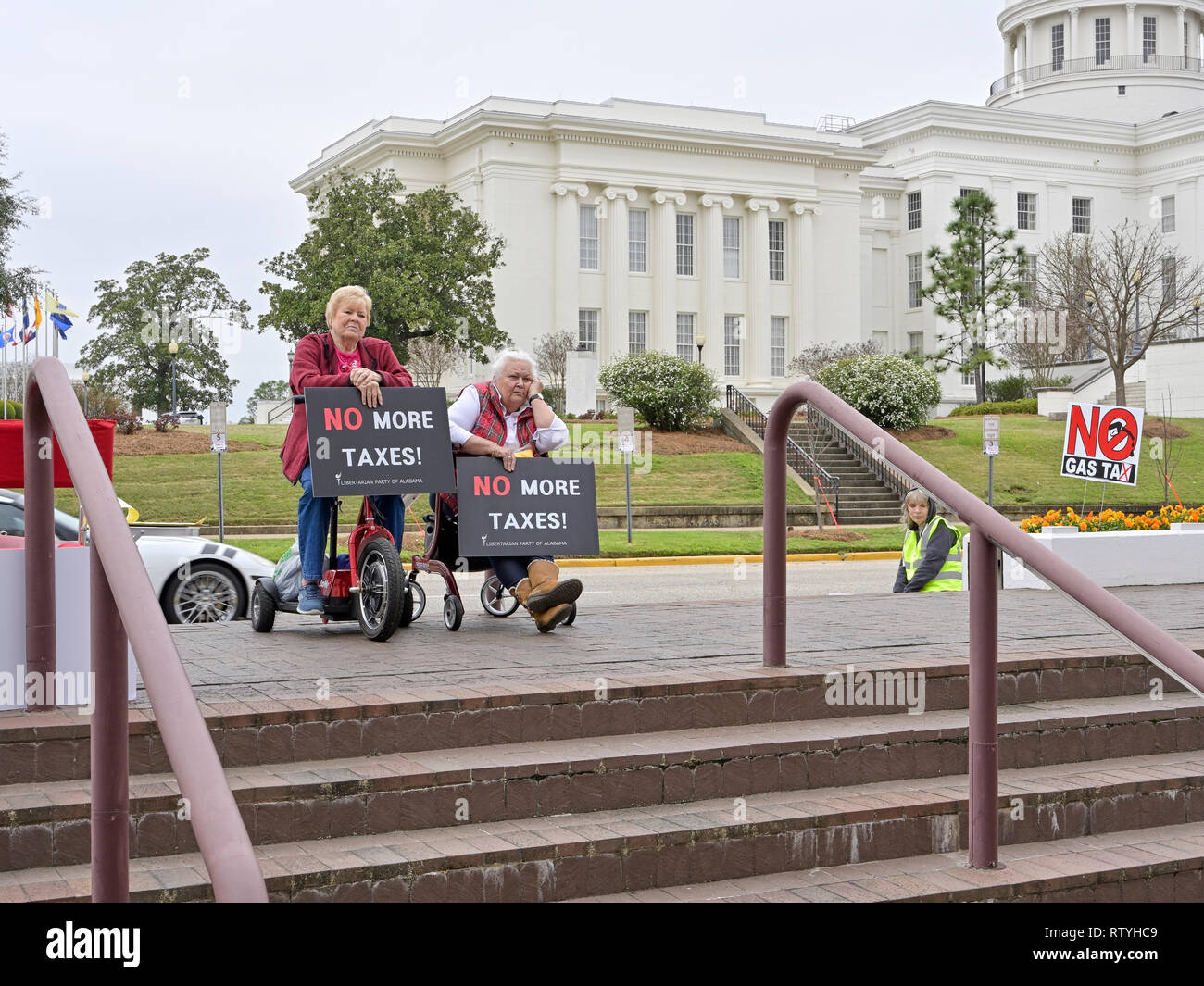 Zwei alte oder ältere Frauen im Rollstuhl tragende Zeichen für keine Steuern mehr hören Sie einen Lautsprecher protestieren Höhere höhere Gas Steuern in Alabama, USA. Stockfoto