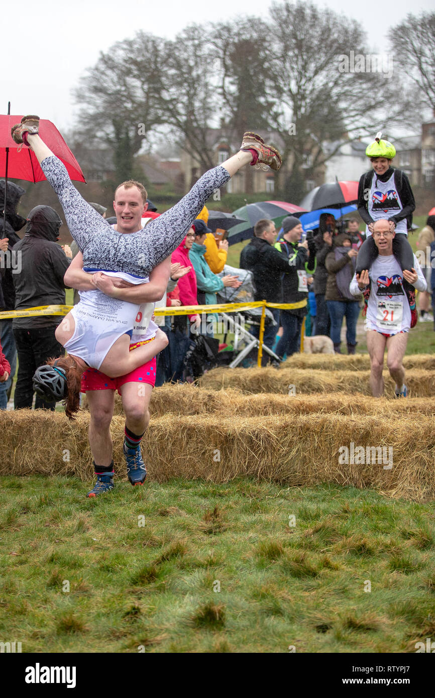 Dorking, Großbritannien, 3. März 2019, Ehemänner, Freunde, tragen ihr Lieben auf den Hügel und wieder zurück über die 380 Meter Rennstrecke für eine Medaille und ein Fass Bier während Der britische Frau Meisterschaften in Dorking, Surry, UK. © Jason Richardson/Alamy Leben Nachrichten statt. Stockfoto