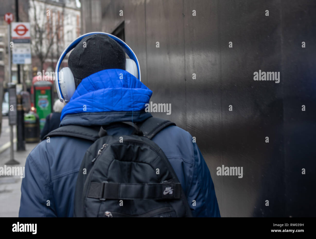 Mann zu Fuß entlang der Straße mit großen Kopfhörer auf Stockfoto