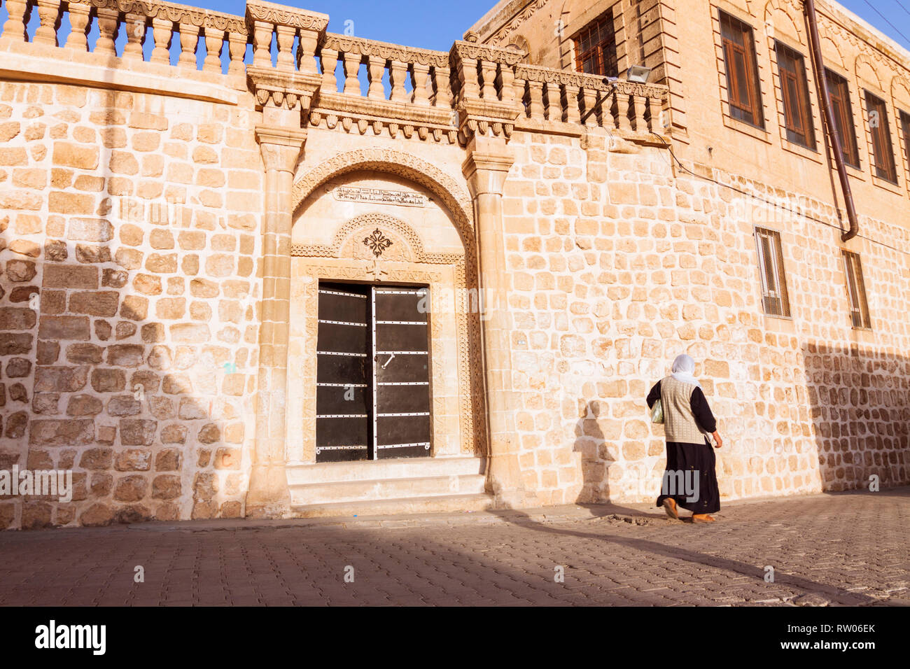 Midyat, Provinz Mardin, Türkei: Eine Frau geht Vergangenheit Mor Barsawmo syrisch-orthodoxe Kirche. Obwohl nun eine Minderheit von weniger als 10 % der Bevölkerung, Stockfoto