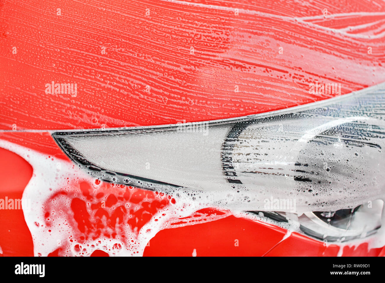 Details zu rotes Auto vorne Licht in der Waschstraße gewaschen. (Farbe kann leicht mit Farbton/Sättigung Tool geändert werden) Stockfoto