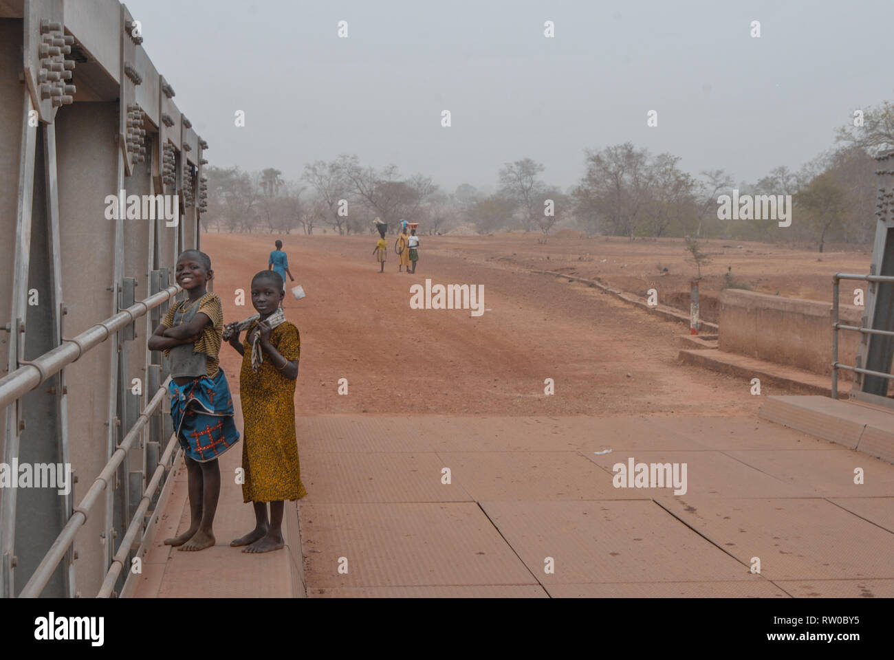 Foto von zwei Stolz und lächelnd Lokale ghanaische Kinder in traditioneller Kleidung und für das Foto auf einem lokalen Brücke posieren. Stockfoto