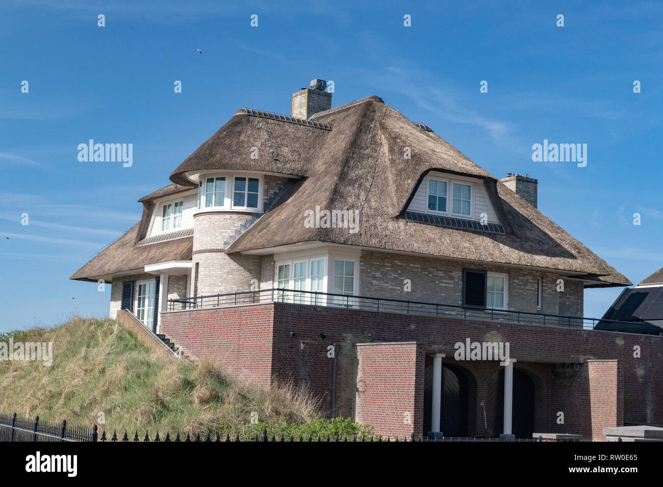 Niederlande, zeeburg, 2017, ein erstaunliches Beispiel von einem Strohdach auf einem roten gemauerte Haus, über der Nordsee. Während einst ein Zeichen der povert Stockfoto