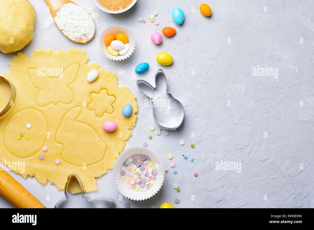 Herstellung von Ostern Cookies, Teig, Ausstechformen, Zucker besprüht, festliche Ostern Backen Hintergrund Stockfoto
