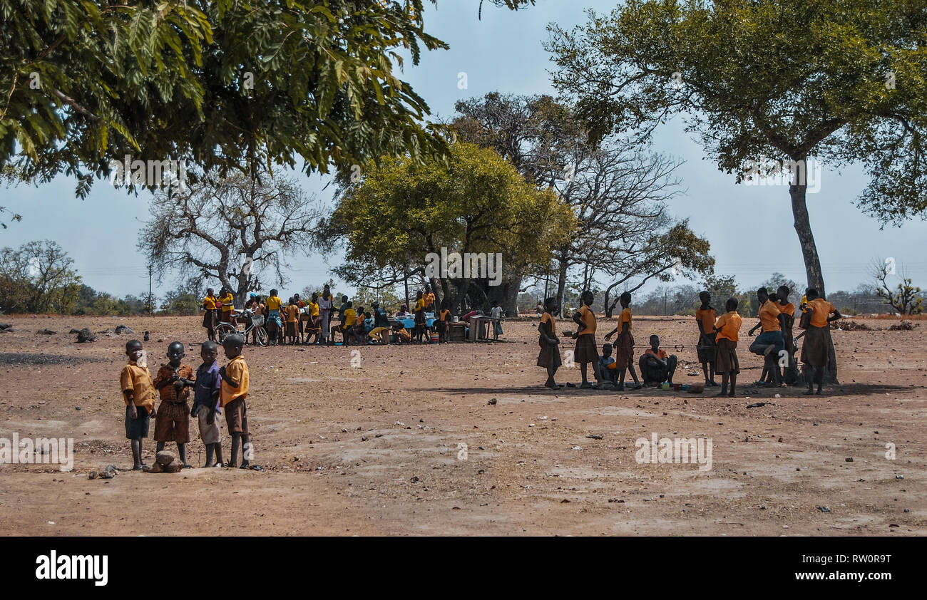 Eine schöne Landschaft Foto der ghanaischen Grundschule Kinder draußen unter einem Baum im Hof und genießen eine Pause zwischen Klassen. Stockfoto