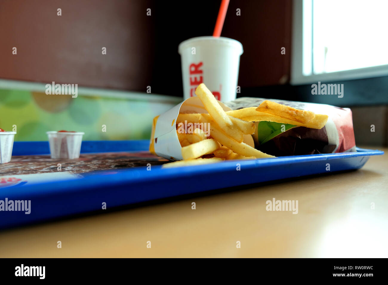 Pommes, einen Whopper hamburger Sandwich und ein Getränk an einem Burger King Lage; Stand und Tisch in einem Burger King Fast Food Restaurant. Stockfoto