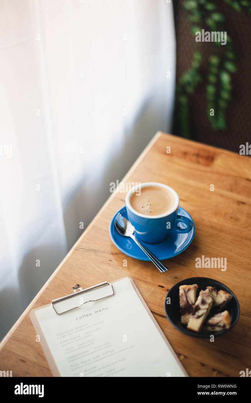 Abstrakte emotionale Szene von heißen Lange schwarze (Americano) in Blau Kaffeetasse auf dem Tisch im Cafe am Morgen Zeit. Wochenende Aktivität und Entspannung. Favorit Stockfoto