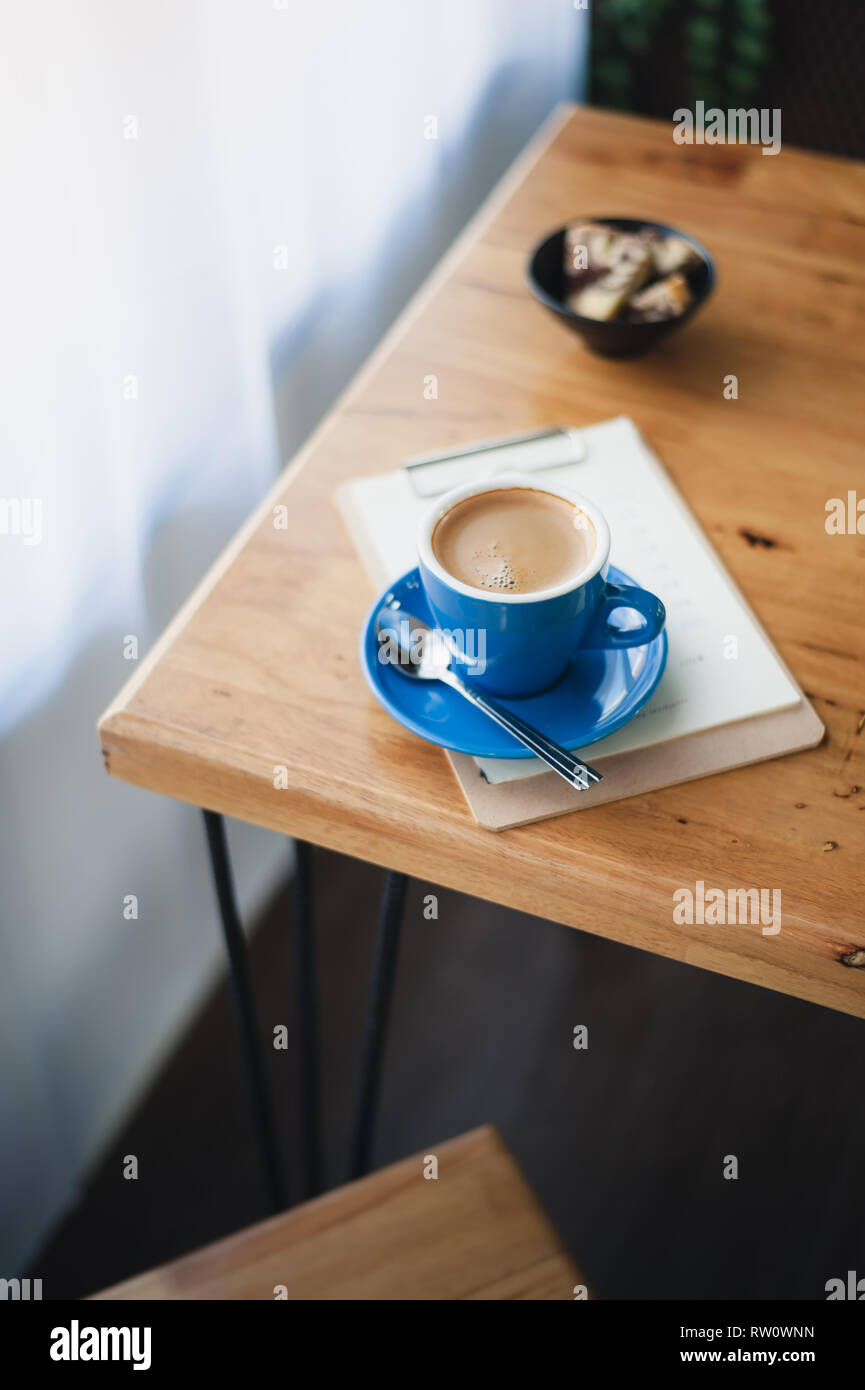 Abstrakte emotionale Szene von heißen Lange schwarze (Americano) in Blau Kaffeetasse auf dem Tisch im Cafe am Morgen Zeit. Wochenende Aktivität und Entspannung. Favorit Stockfoto