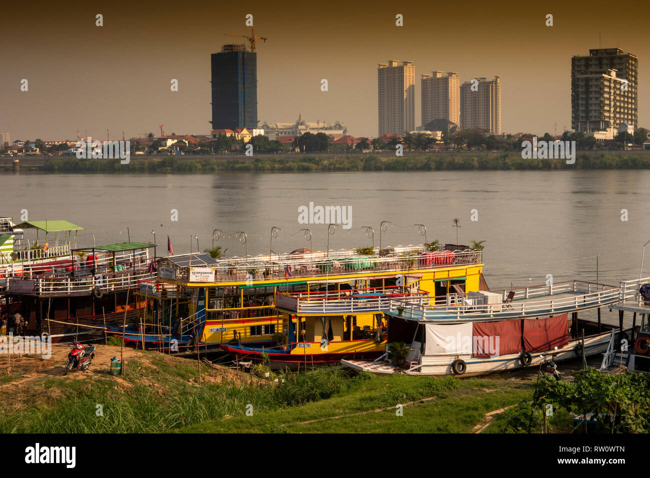 Kambodscha, Phnom Penh, Stadtzentrum, sisowath Quay, River Cruise Boote gefesselt am Flussufer gegenüber neuen deveopments auf Chroy Changvar Stockfoto