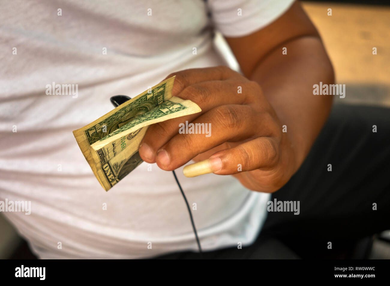 Kambodscha, Phnom Penh, Stadtzentrum, hand Tuk Tuk Fahrer's mit langen Fingernagel holding US Dollar Hinweis Stockfoto