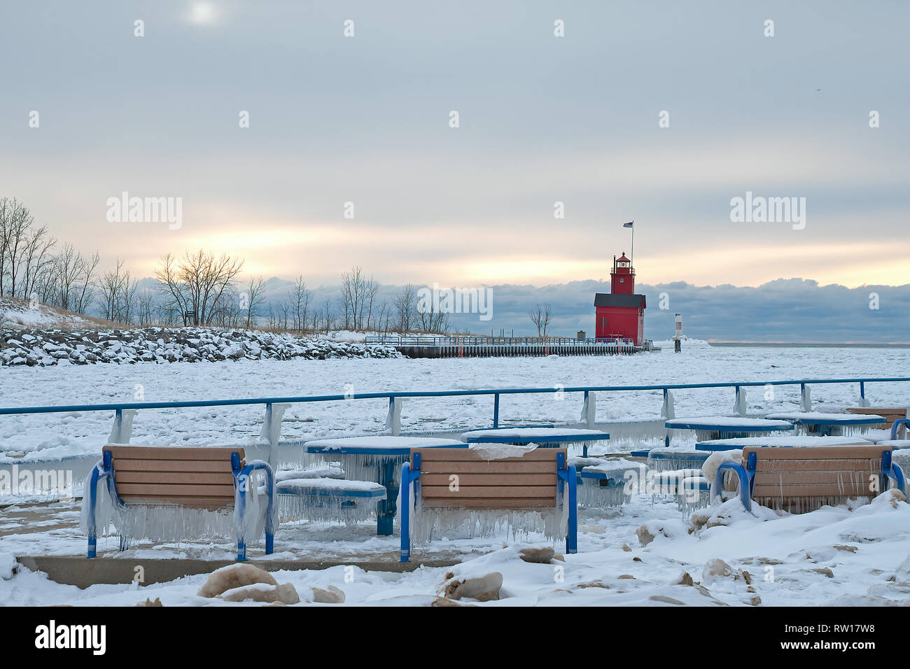 Holland Hafen rot Leuchtturm im Winter mit Eis auf Parkbänken und Tabellen Stockfoto
