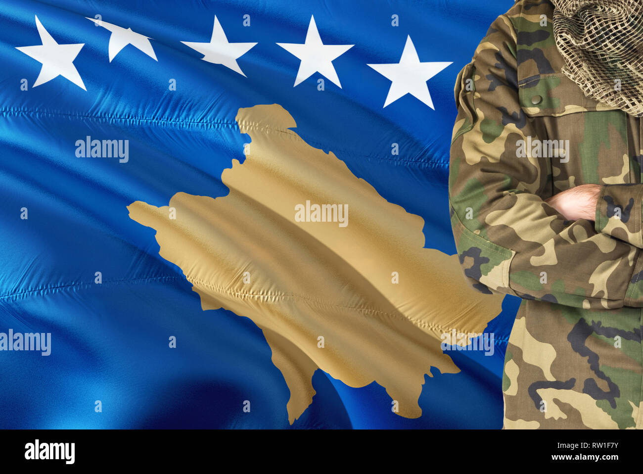 Gekreuzte Arme Soldat mit nationalen wehende Flagge auf Hintergrund - im Kosovo Thema. Stockfoto