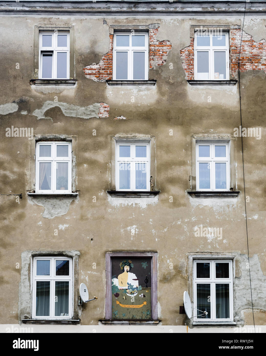 Wandbild zwischen Windows auf einer Fassade eines heruntergekommenen Gebäude im Stadtteil Kazimierz in Krakau, Polen Stockfoto