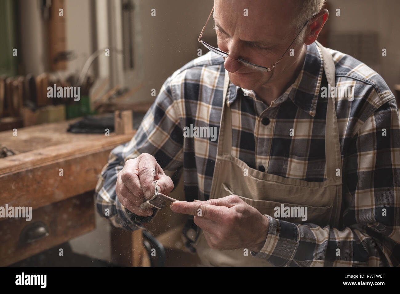 Reifen artisan In einem Workshop nach unten Schleifen einer Geige Bogen manuell Stockfoto