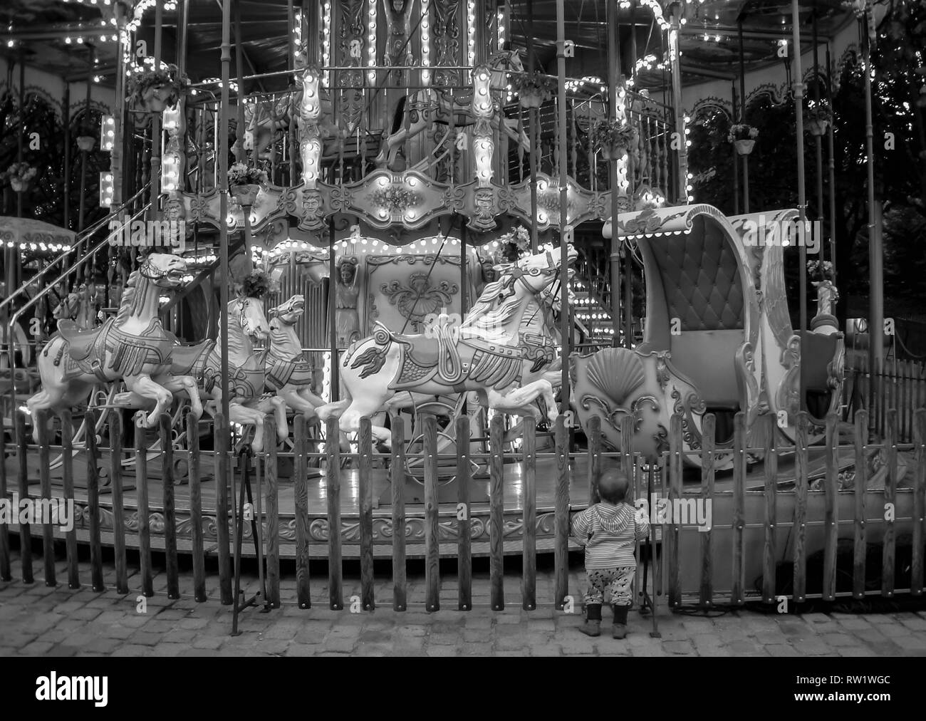 PARIS KINDER KARUSSELL - kleines Kind SICH AUF EIN KARUSSELL IN DER NACHT - PARIS - PARIS KINDER UNTERHALTUNG - STREET FOTOGRAFIE - PARIS PARC - SCHWARZ UND WEISS ARCHIV FOTOGRAFIE © Frédéric BEAUMONT Stockfoto