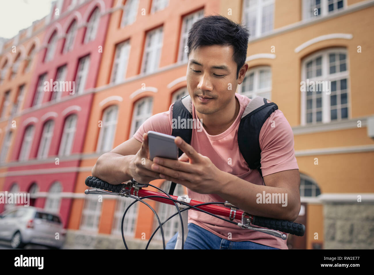 Junge Mann sitzt auf seinem Fahrrad eine Textnachricht senden Stockfoto