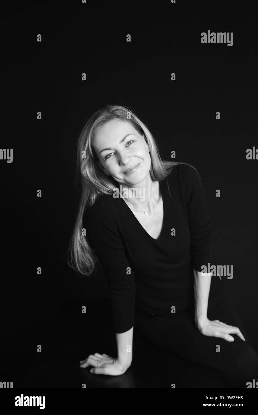 In der Nähe von Studio Portrait einer schönen Frau im schwarzen Kleid auf schwarzem Hintergrund Stockfoto
