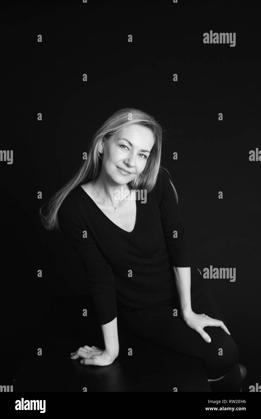 In der Nähe von Studio Portrait einer schönen Frau im schwarzen Kleid auf schwarzem Hintergrund Stockfoto