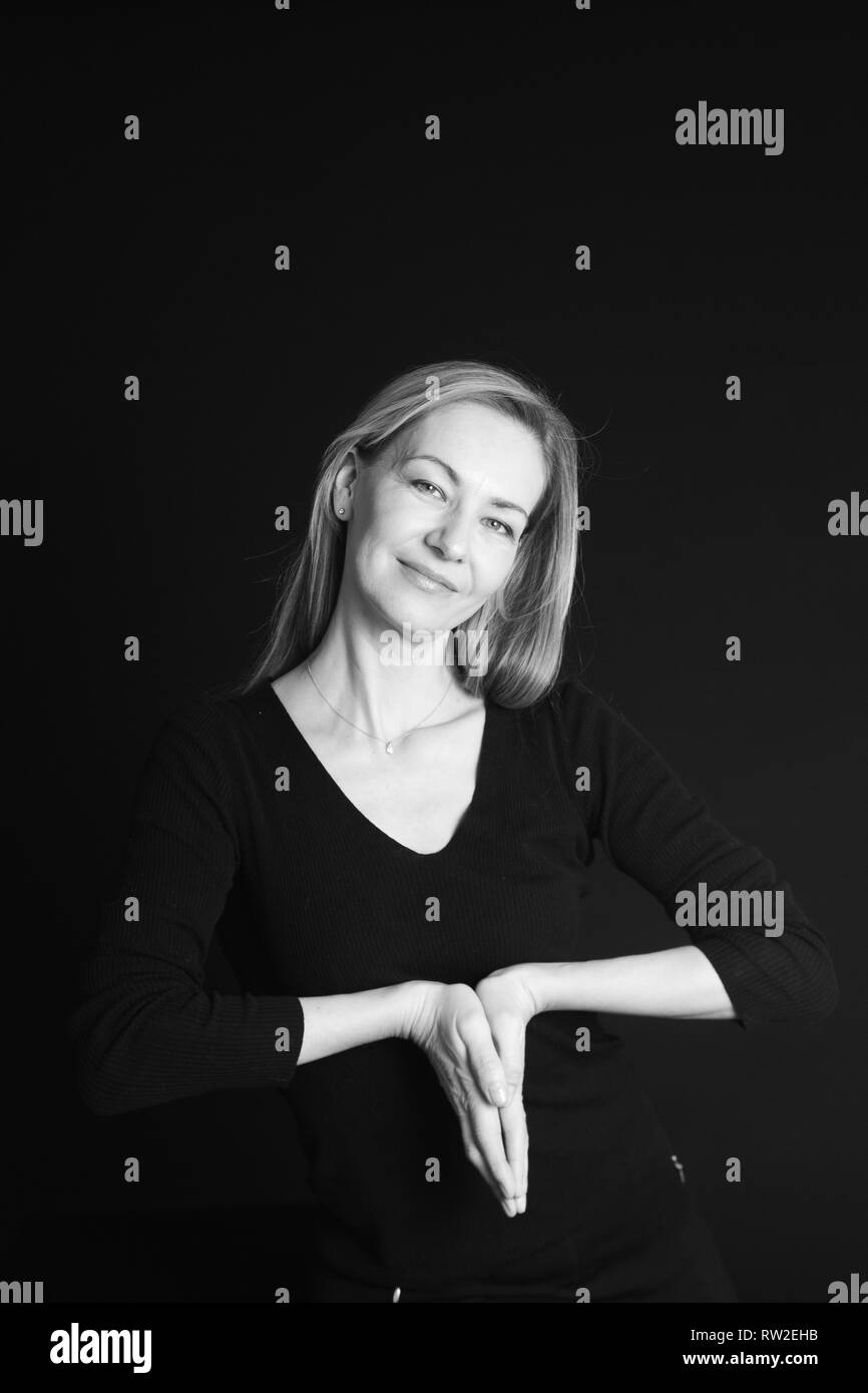 In der Nähe von Studio Portrait einer schönen Frau im schwarzen Kleid auf schwarzem Hintergrund Stockfoto