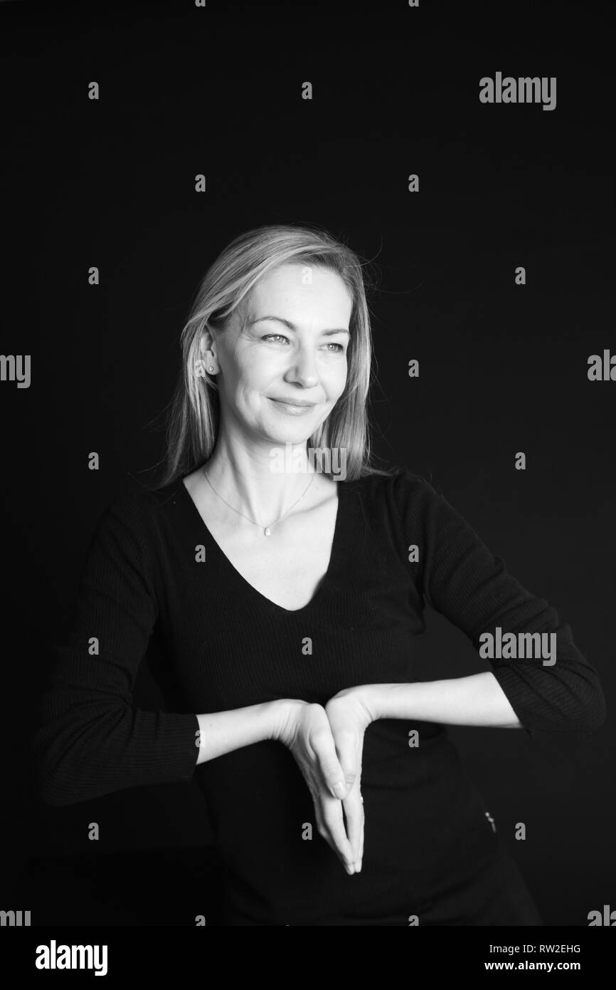 In der Nähe von Studio Portrait einer schönen Frau im schwarzen Kleid auf schwarzem Hintergrund Stockfoto