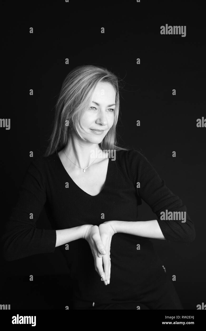 In der Nähe von Studio Portrait einer schönen Frau im schwarzen Kleid auf schwarzem Hintergrund Stockfoto