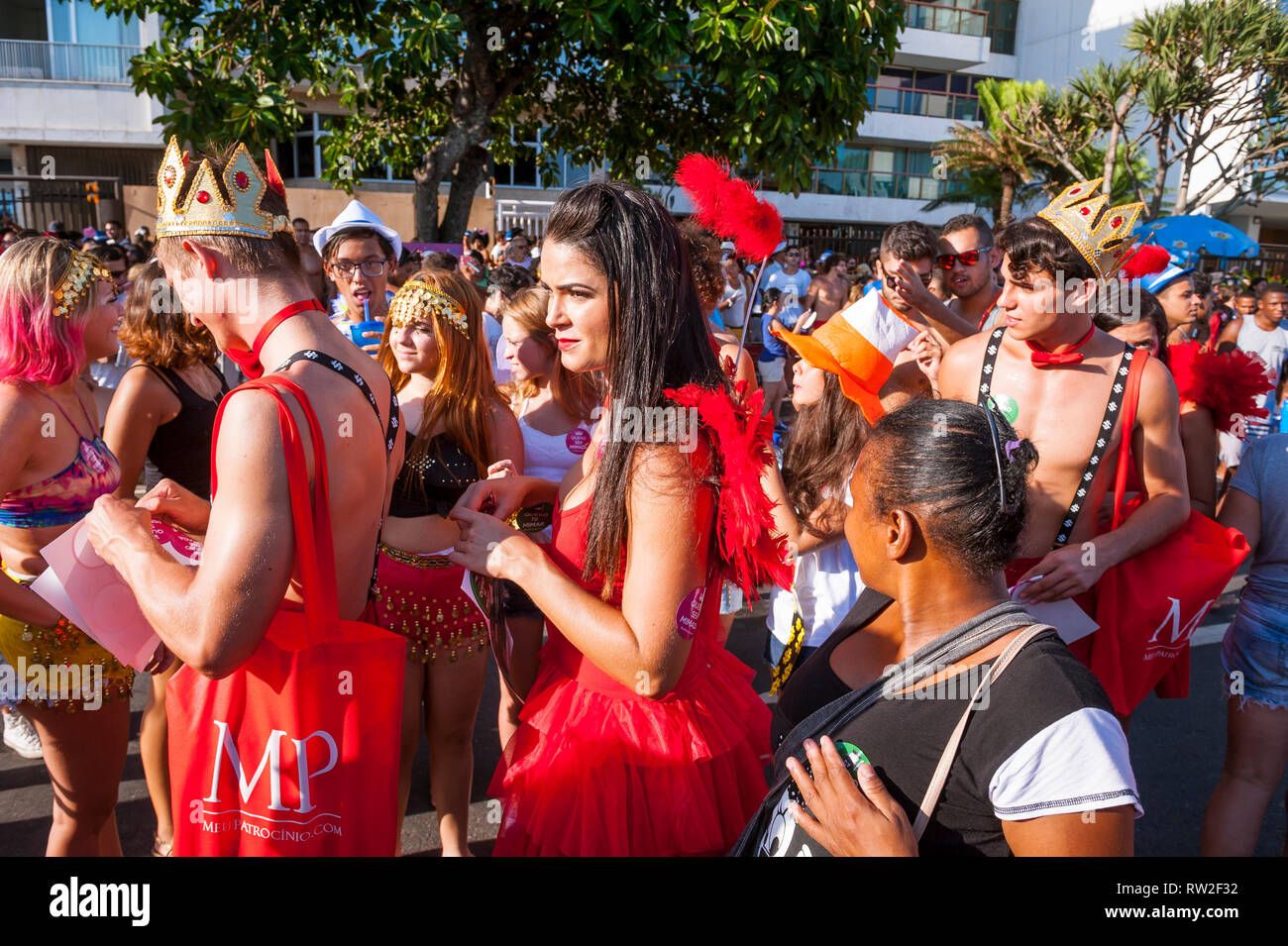 RIO DE JANEIRO - Februar 18, 2017: Der junge Brasilianer in bunten Kostümen hand Werbeaufkleber an einem Nachmittag Karneval Straßenfest. Stockfoto
