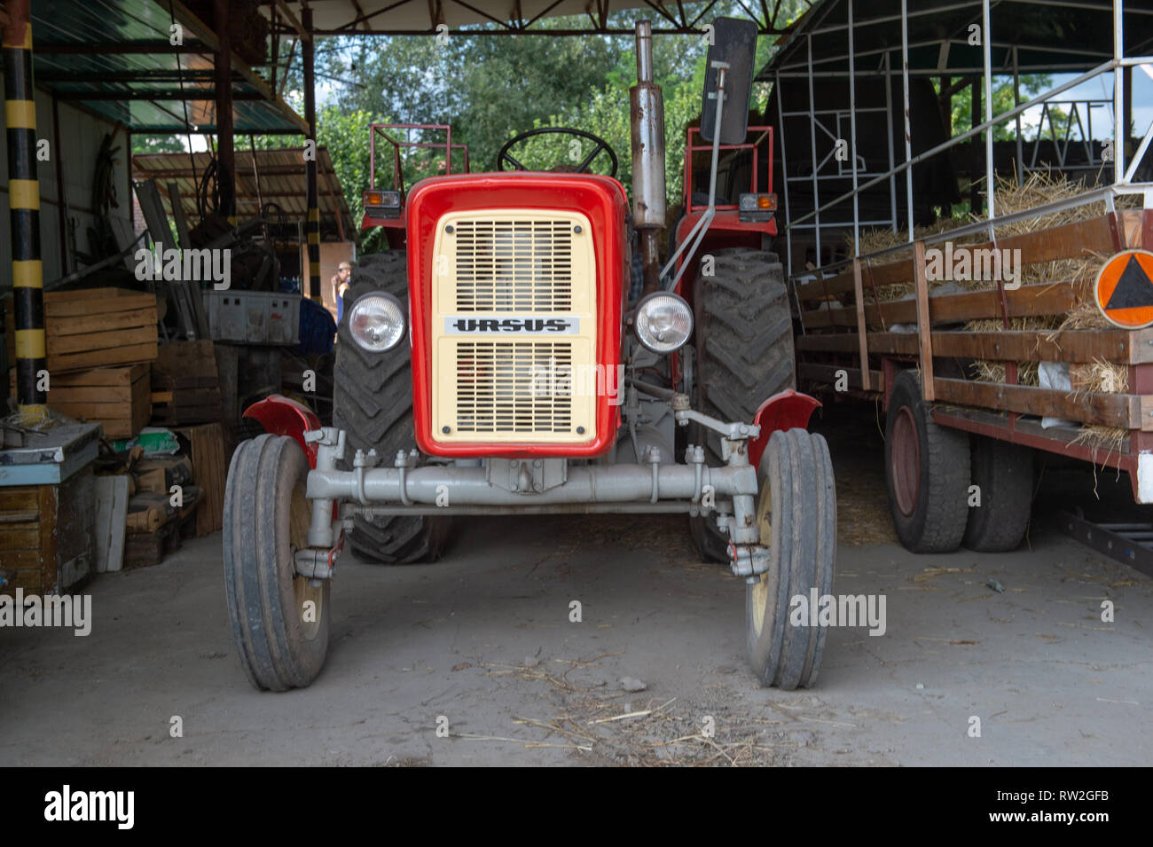 Vorderen winkel Blick auf polnische hergestellten Traktor unter überdachte Garage, Pszczółki, Woiwodschaft Pommern, Polen geparkt Stockfoto